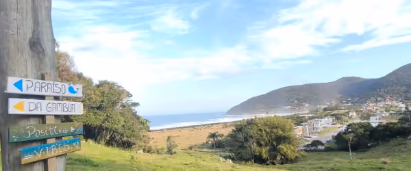 Placa de acesso e vegetação na chegada à Praia da Gamboa